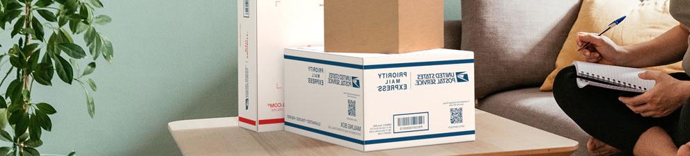 Domestic mail and shipping service product boxes sitting on a table.